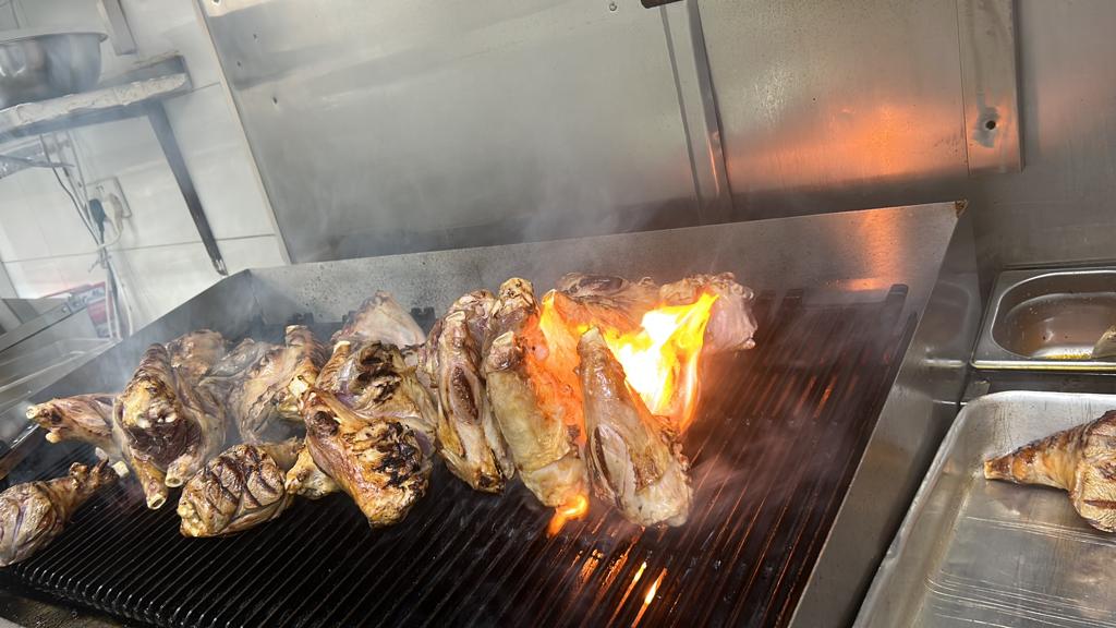 Meat cooking over an open flame in the kitchen